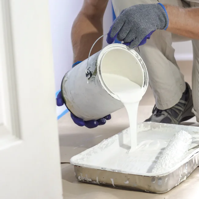 painting contractor pouring paint on a tray during interior painting service aberdeen wa